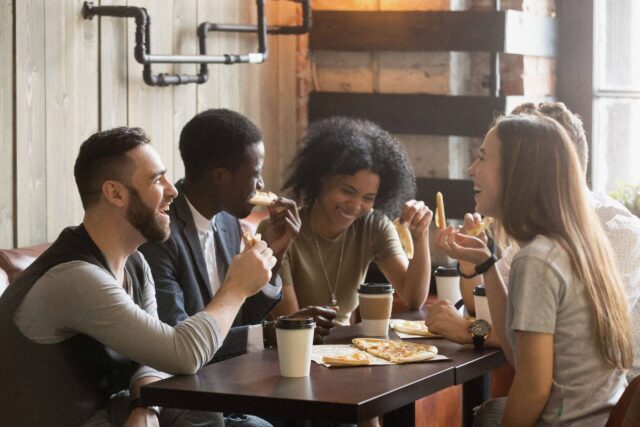 A group of people sitting around a table smiling - accessibility apps