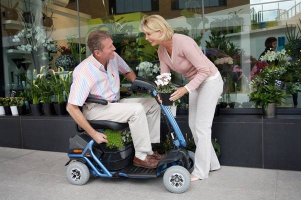 man on a mobility scooter with a lady talking to him