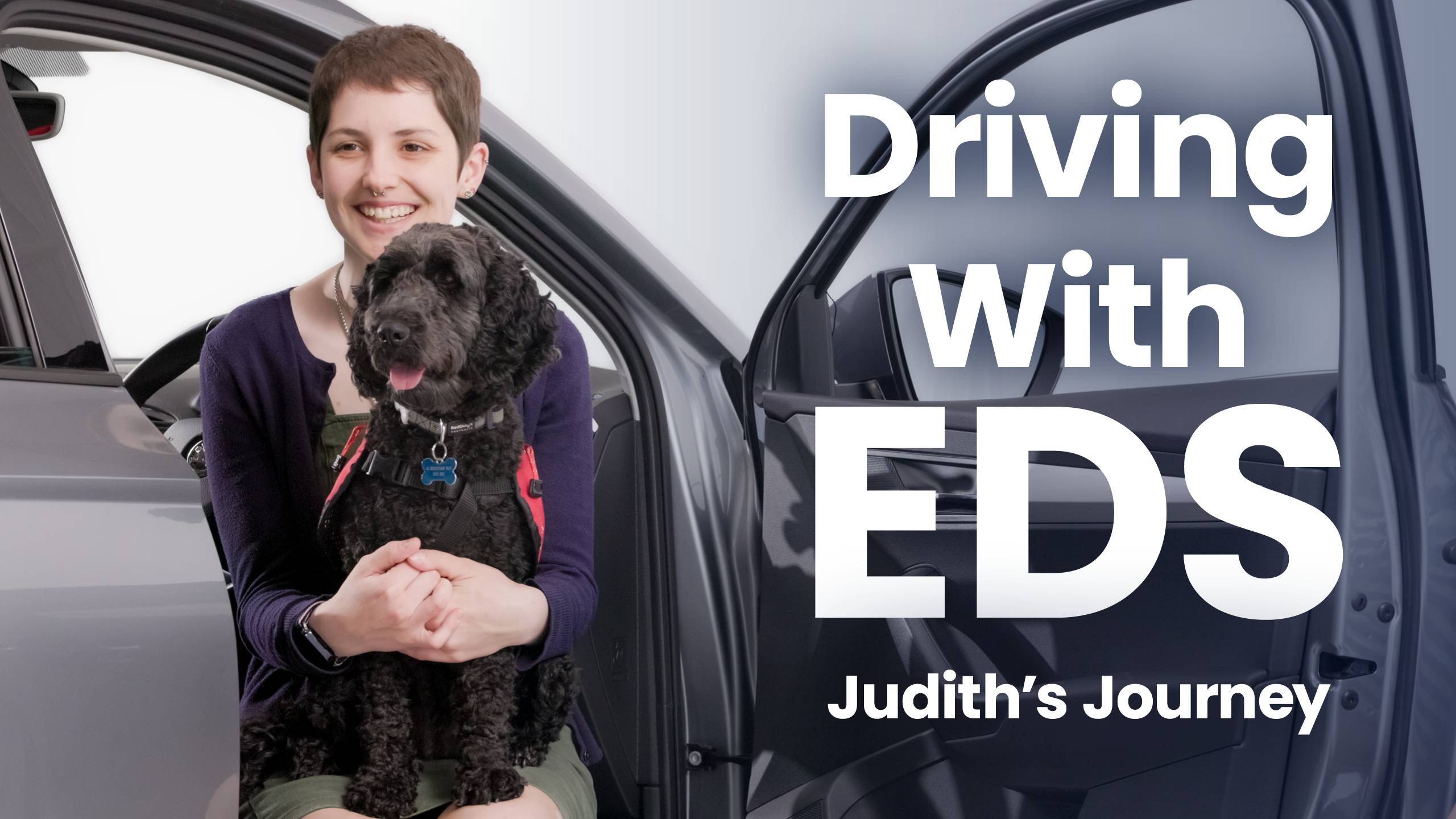 Judith with her assistance dog in car smiling - Driving With EDS