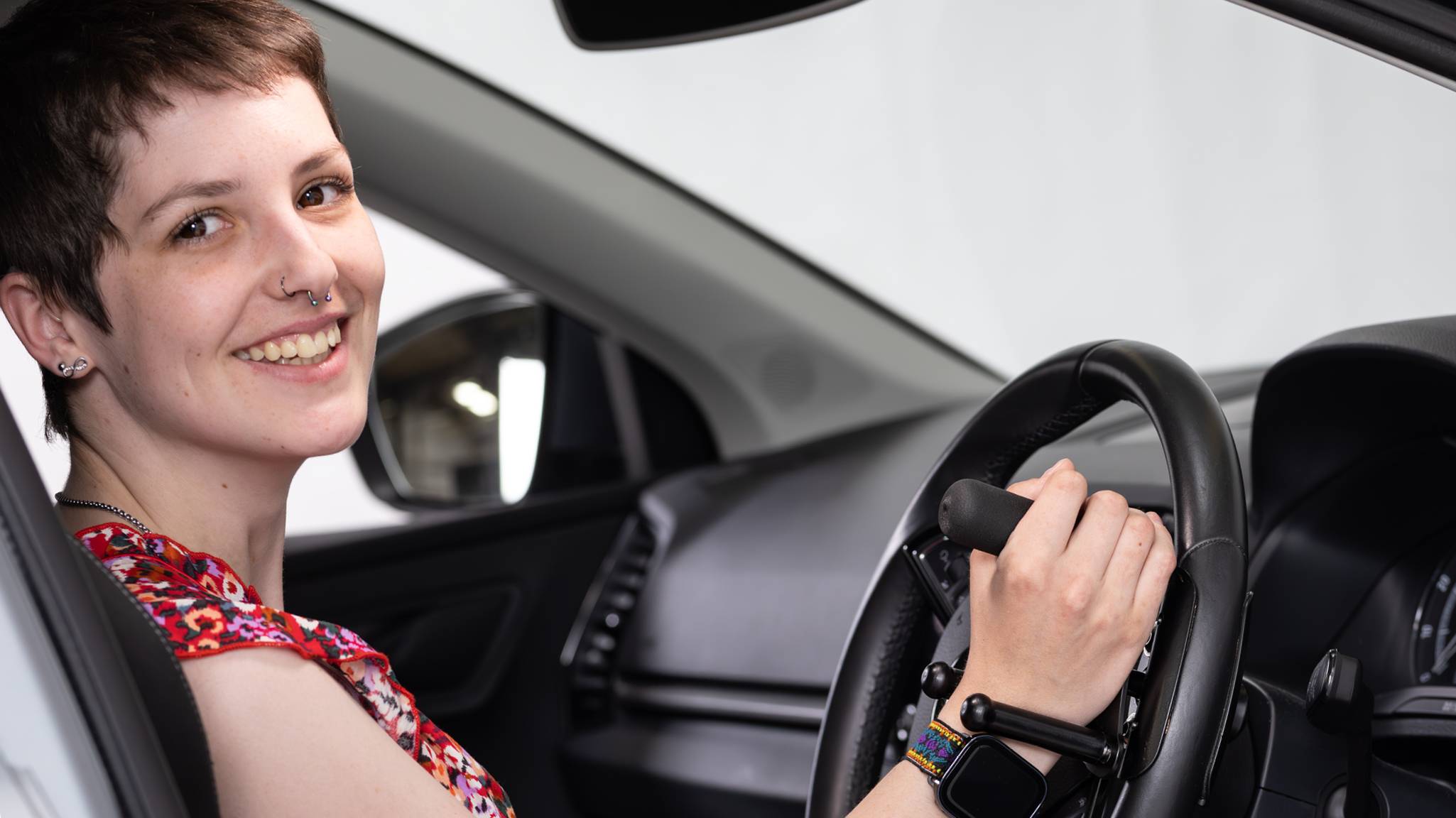 Judith smiling whilst using the tetra grip steering aid