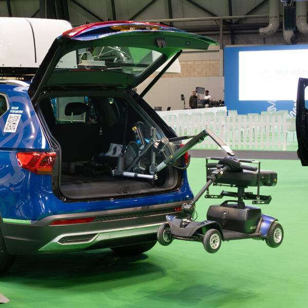 The back of a car with its boot open. A Boot Hoist is holding up a scooter. A Power Pack is attached to the frame of the boot hoist.