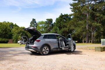 what vehicles can be wheelchair accessible blog - grey audi e-tron with boot hoist lifting a mobility scooter and a swivel seat turned out of the drivers side.