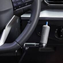 the handle of push pull mechanical hand controls next to the steering wheel in a car. The handle has a switch on top to control the indicators