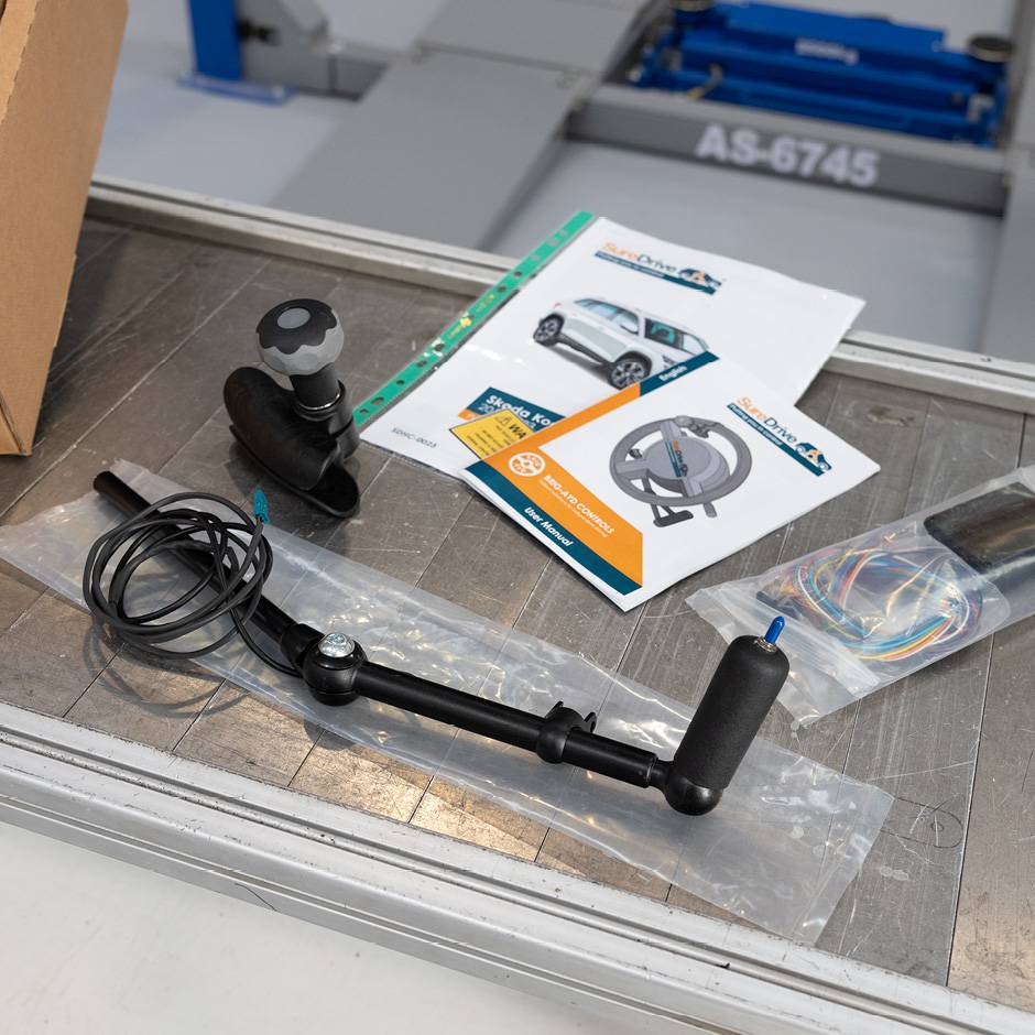 a work bench with the component parts of hand controls laid out