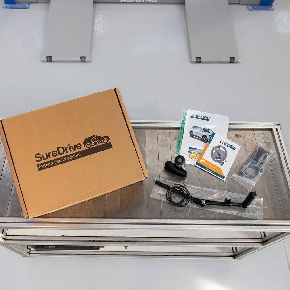 a work bench with the component parts of hand controls laid out