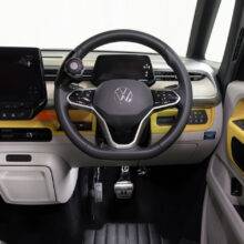 A driver's seat view of a car interior. There is a steering ball on the steering whee. In the footwell the accelerator is folded up and out of the way, a second accelerator pedal has been folded down to the left of the accelerator pedal.