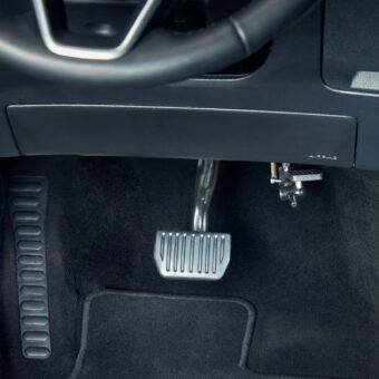 A driver's seat view of a car interior. In the footwell the accelerator is folded up and out of the way.