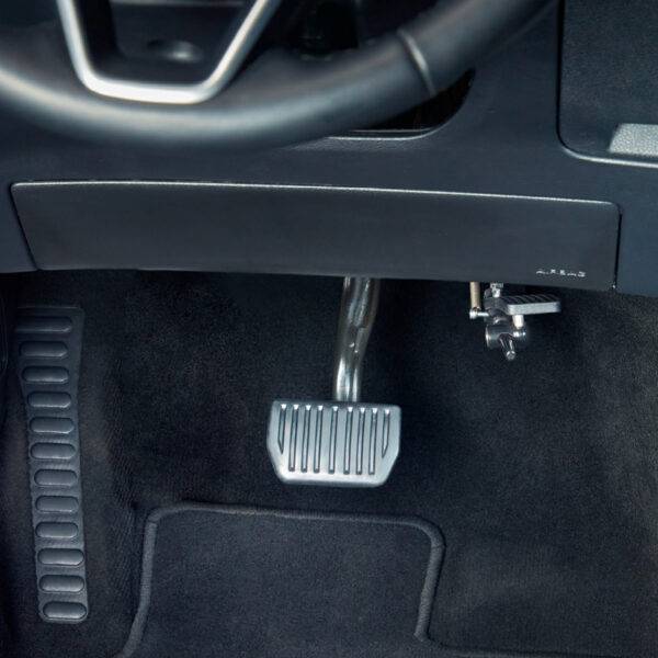 A driver's seat view of a car interior. In the footwell the accelerator is folded up and out of the way.