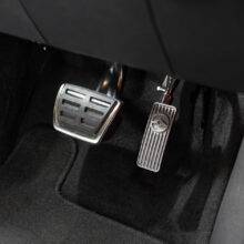 A driver's seat view of a car interior. In the footwell the accelerator has a hinge visible above it, allowing it to be folded up and out of the way