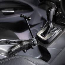 A car's handbrake with a minimalist T-shaped handle attached to it.
