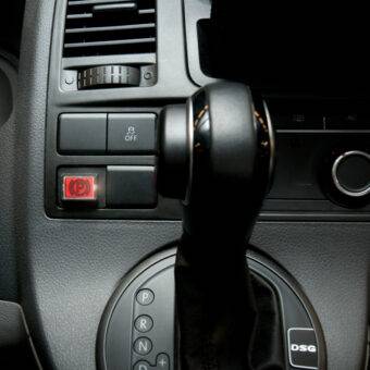 The dashboard of a car showing a new buttong marked "P" for an electric easy release handbrake