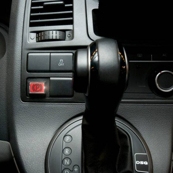 The dashboard of a car showing a new buttong marked "P" for an electric easy release handbrake