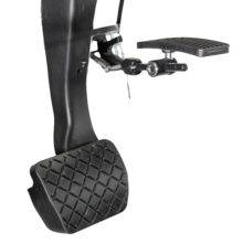 A car brake pedal and a hanged accelerator pedal. The accelerator is folded up out of the way.