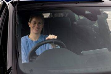 how to adapt a car for disabled driver blog - Robyn Love smiling in drivers seat using steering aid