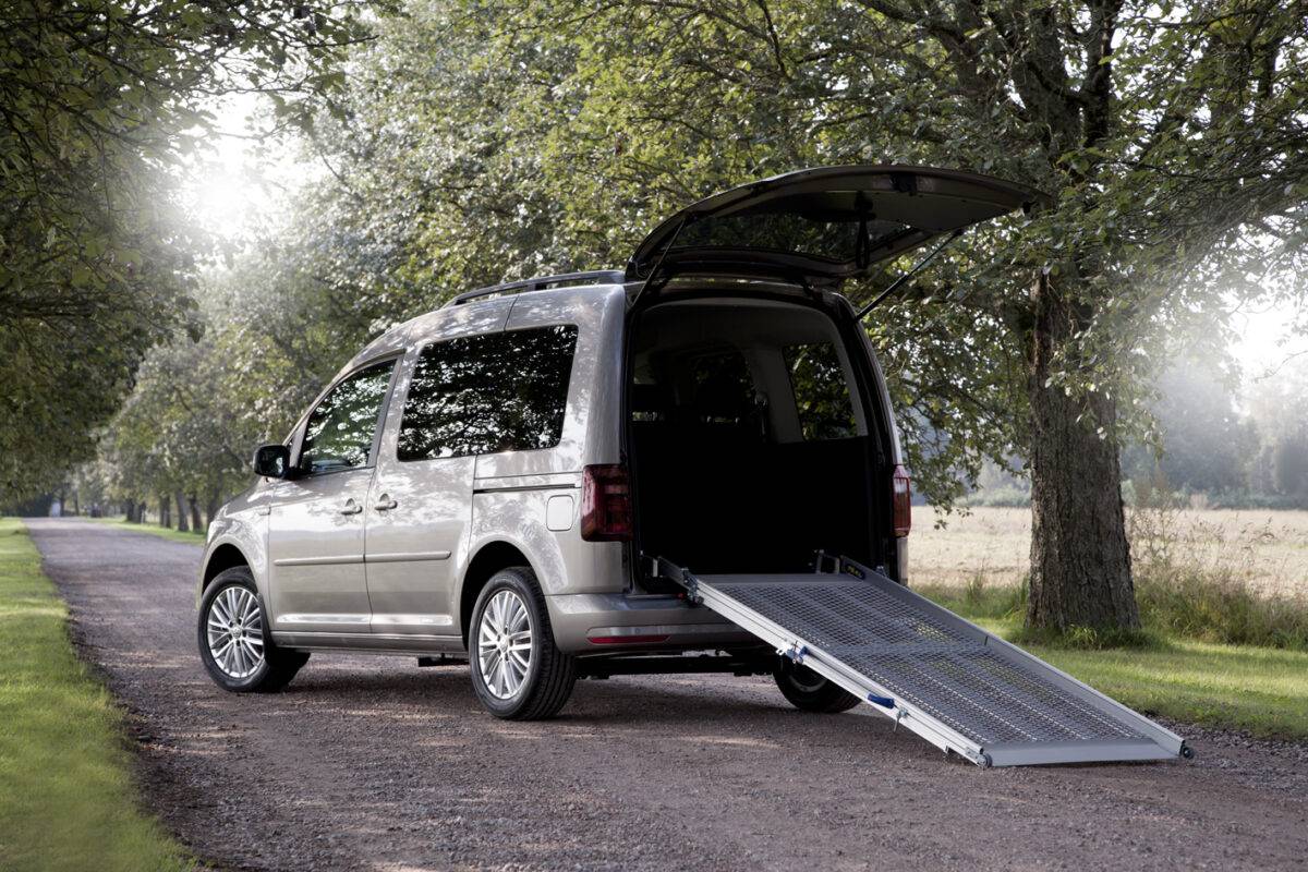Silver van with rear open showing a wheelchair ramp