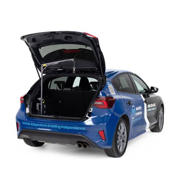 The boot of a Ford Focus with the Brig-Ayd 40kg Boot Hoist, a tall, slender, folding and collapsible hoist arm with a green lifting cord and clip for multiple types of mobility device.