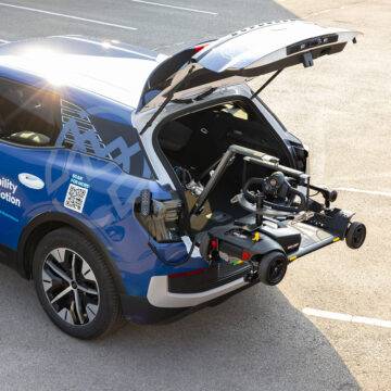 The open boot of an EV car with the Autochair Smart Lifter LC Boot Hoist lifting a mobility scooter.