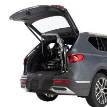 The open boot of a car showing a scooter loaded into the boot by the Autochair Smart Lifter LM folding Boot Hoist.