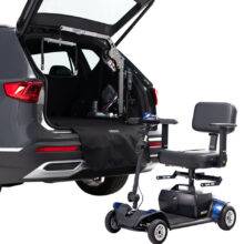 The open boot of a car with the Autochair Smart Lifter LM Folding Boot Hoist for lifting mobility devices. Outside the car a mobility scooter has the Autochair Smart Scooter seat installed