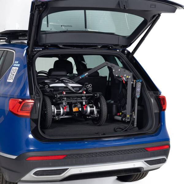 The open boot of a car showing a folding power chair loaded into the boot by the Autochair Smart Lifter LM folding Boot Hoist.