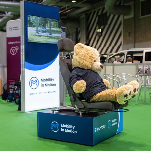 A giant teddy bear is happily modelling the function of a swivel seat with a BraunAbility Turnout swivel base and the BEV seat.