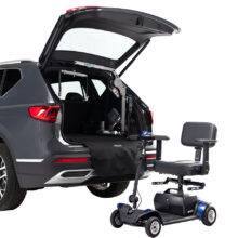 The open boot of a car with a boot hoist for lifting mobility devices. Outside the car a mobility scooter has the Autochair Smart Scooter seat installed