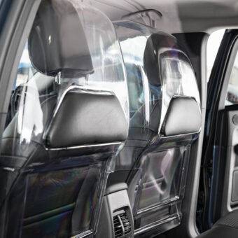 The rear seats of a car separated from the front passenger and driver by a robust transparent polycarbonate Driver shield for safely. The screen has additional padded panels to reduce the risk of injury.