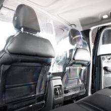 The rear seats of a car separated from the front passenger and driver by a robust transparent polycarbonate Driver shield for safely. The screen has additional padded panels to reduce the risk of injury.