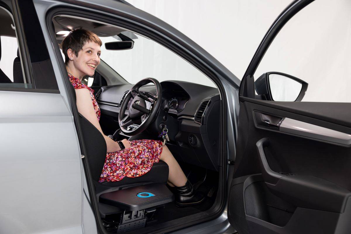 Judith King sitting in drivers seat with Autochair Transfer Plate