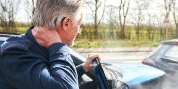 Man looking over his shoulder at a minor car accident. Wondering about his Motability insurance