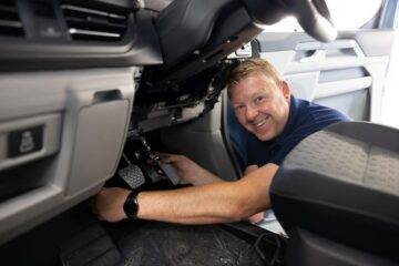 vehicle adaptation installer smiling while fitting pedal adaptations