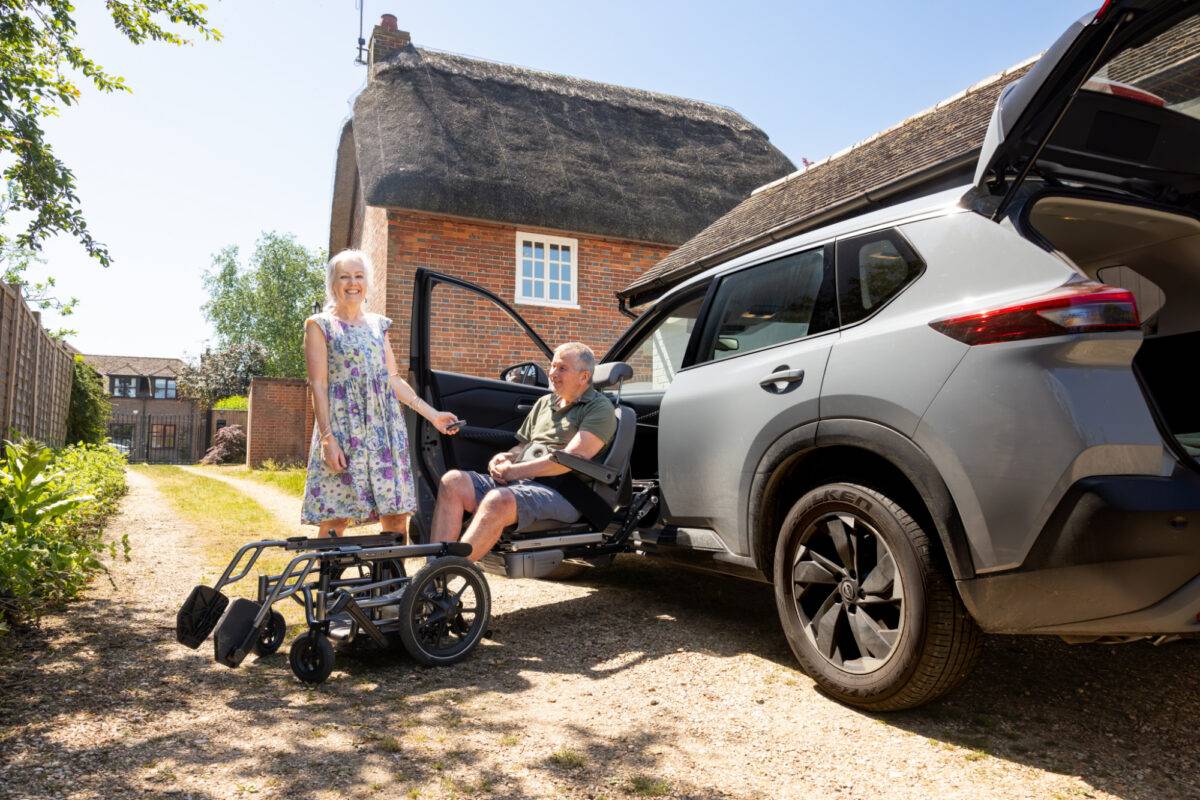 Elizabeth and Ian posing with the wheelchair carony swivel seat fitted in their Nissan X Trail Adapt & Drive car