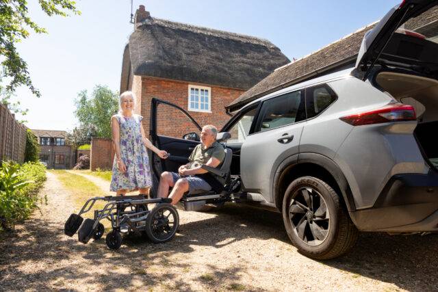 Elizabeth and Ian posing with the wheelchair carony swivel seat fitted in their Nissan X Trail Adapt & Drive car