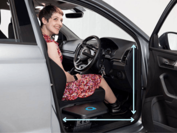 Young woman sat in drivers seat smiling with a transfer plate fitted. Arrows highlight the door width and door height. 