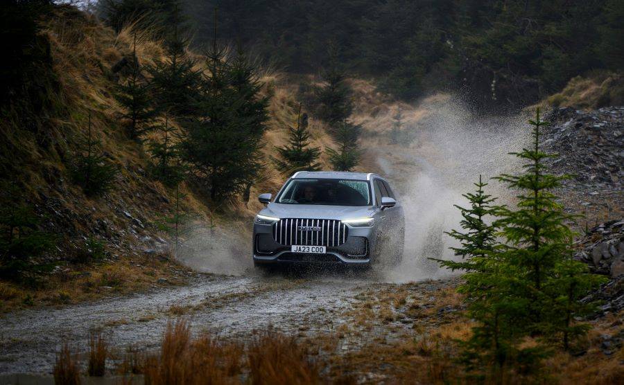 Front shot of silver JAECOO 8 driving down an off road in scotland