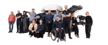 mobility in motion team members stood around an adapted car