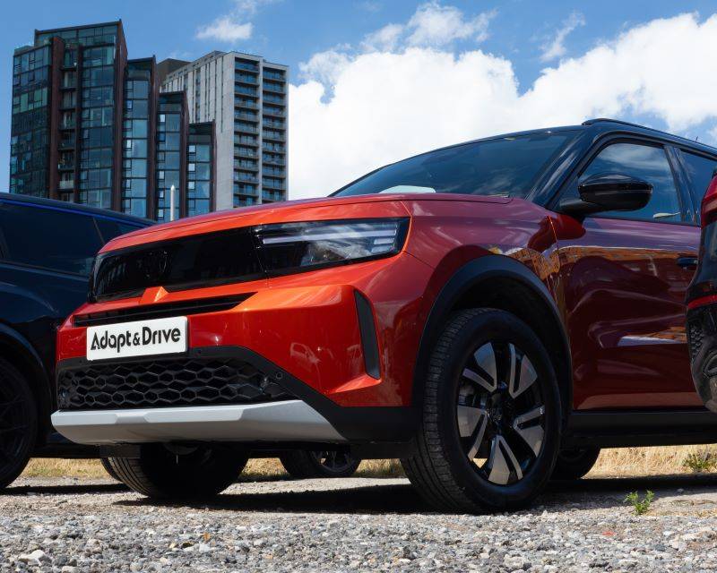 Red Vauxhall Frontera Adapt & Drive car with skyscrapers lining the background