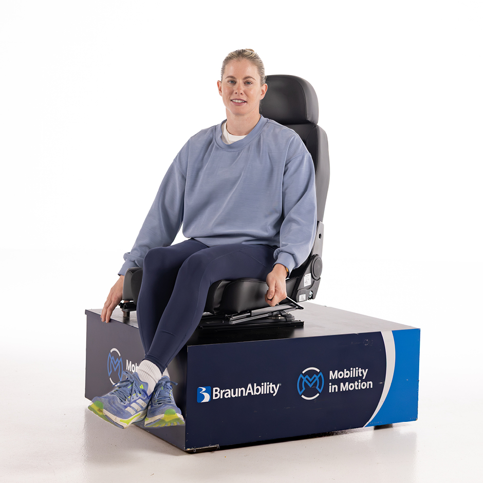 Robyn Love in a studio demonstrating a BraunAbility manual swivel seat.